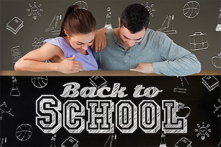 simsearch:400-07682840,k - Young couple looking down a wall against blackboard on wall Fotografie stock - Microstock e Abbonamento, Codice: 400-07682879