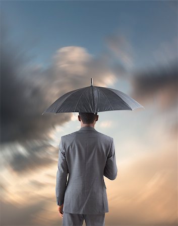 simsearch:400-07665425,k - Businessman standing under umbrella against blue and orange sky with clouds Stockbilder - Microstock & Abonnement, Bildnummer: 400-07682897