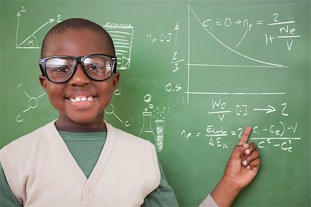 simsearch:400-07682840,k - Cute pupil pointing against math and science doodles Fotografie stock - Microstock e Abbonamento, Codice: 400-07683138