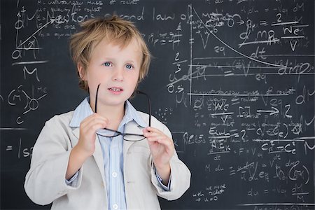 simsearch:400-07682840,k - Cute pupil holding glasses against math and science doodles Fotografie stock - Microstock e Abbonamento, Codice: 400-07683144