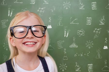 simsearch:400-07682840,k - Cute pupil smiling against school doodles Fotografie stock - Microstock e Abbonamento, Codice: 400-07683146