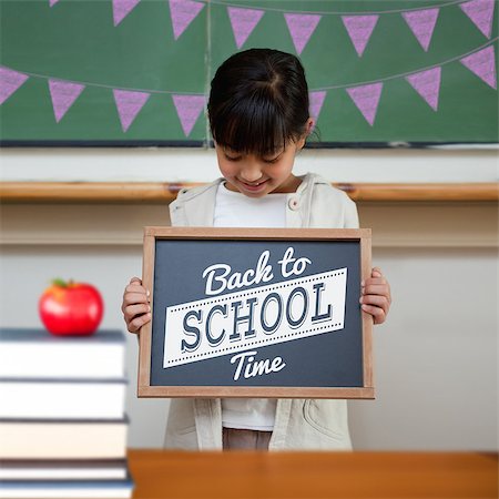 school girl holding pile of books - Back to school message against cute pupil showing chalkboard Stock Photo - Budget Royalty-Free & Subscription, Code: 400-07683420