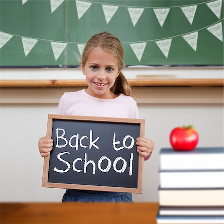 school girl holding pile of books - Back to school message against cute pupil showing chalkboard Stock Photo - Budget Royalty-Free & Subscription, Code: 400-07683421