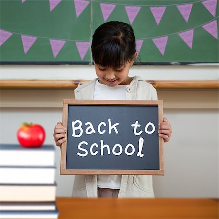 school girl holding pile of books - Back to school message against cute pupil showing chalkboard Stock Photo - Budget Royalty-Free & Subscription, Code: 400-07683422