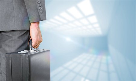 simsearch:400-08020381,k - Businessman holding briefcase against room with windows at ceiling Fotografie stock - Microstock e Abbonamento, Codice: 400-07683669
