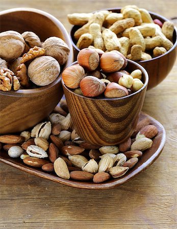 simsearch:400-07310170,k - different kinds of nuts (almonds, walnuts, hazelnuts, peanuts) in a bowl on a wooden table Fotografie stock - Microstock e Abbonamento, Codice: 400-07714064