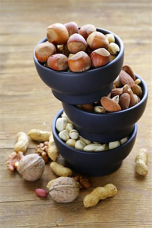 simsearch:400-07310170,k - different kinds of nuts (almonds, walnuts, hazelnuts, peanuts) in a bowl on a wooden table Fotografie stock - Microstock e Abbonamento, Codice: 400-07714061