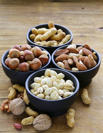 simsearch:400-07310170,k - different kinds of nuts (almonds, walnuts, hazelnuts, peanuts) in a bowl on a wooden table Fotografie stock - Microstock e Abbonamento, Codice: 400-07714062