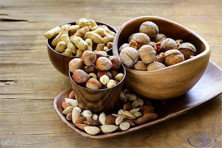 simsearch:400-07310170,k - different kinds of nuts (almonds, walnuts, hazelnuts, peanuts) in a bowl on a wooden table Fotografie stock - Microstock e Abbonamento, Codice: 400-07714063