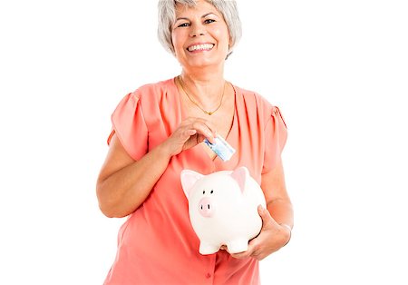 family money box - Portrait of a happy old woman putting money on  a piggy bank, isolated on a white background Stock Photo - Budget Royalty-Free & Subscription, Code: 400-07714437