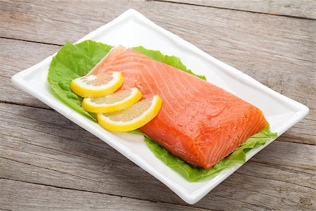 salmon on a colored plate - Fresh salmon fish with lemon and salad leaves on wooden table Stock Photo - Budget Royalty-Free & Subscription, Code: 400-07715021