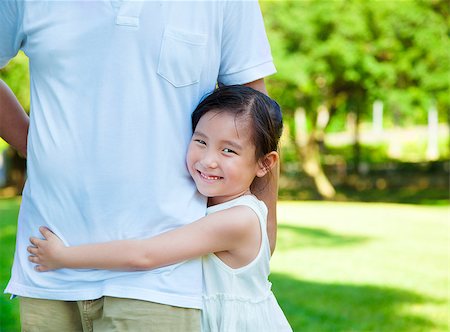 family relaxing with kids in the sun - pretty little girl hug father waist in the park Stock Photo - Budget Royalty-Free & Subscription, Code: 400-07715954