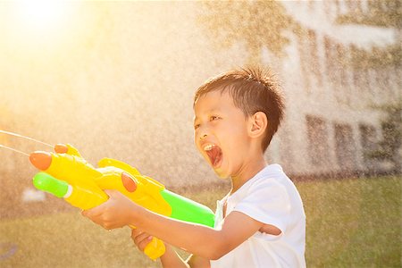 little boy shouting and playing water guns in the park Stock Photo - Budget Royalty-Free & Subscription, Code: 400-07715960