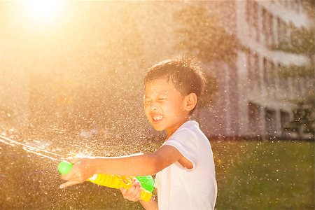 Cheerful little boy playing water guns in the park Stock Photo - Budget Royalty-Free & Subscription, Code: 400-07715961