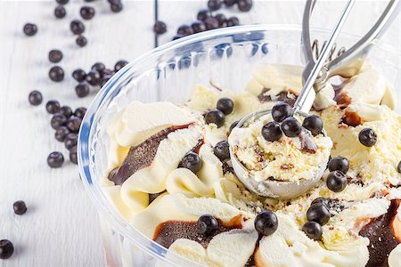 Vanilla and chocolate ice cream with blackberries scoop scooped out of a container on white wooden background Photographie de stock - Aubaine LD & Abonnement, Code: 400-07716298