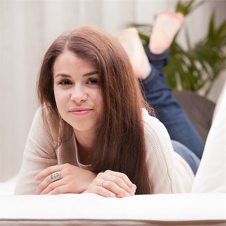 self confident beautiful young girl on a couch watching you and maybe a new idea she had Stockbilder - Microstock & Abonnement, Bildnummer: 400-07716434