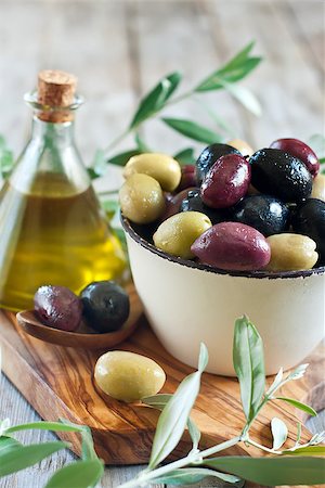 simsearch:400-07219392,k - Mixed marinated olives (green, black and purple) in ceramic bowl and wooden spoon with bottle of olive oil. Selective focus. Stock Photo - Budget Royalty-Free & Subscription, Code: 400-07716738
