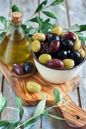 simsearch:400-07219392,k - Mixed marinated olives (green, black and purple) in ceramic bowl and wooden spoon with bottle of olive oil. Selective focus. Stock Photo - Budget Royalty-Free & Subscription, Code: 400-07716739