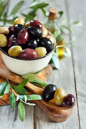 simsearch:400-07219392,k - Mixed marinated olives (green, black and purple) in ceramic bowl and wooden spoon with bottle of olive oil. Selective focus. Stock Photo - Budget Royalty-Free & Subscription, Code: 400-07716744