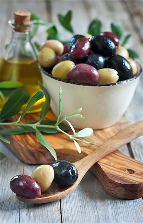 simsearch:400-07219392,k - Mixed marinated olives (green, black and purple) in ceramic bowl and wooden spoon with bottle of olive oil. Selective focus. Stock Photo - Budget Royalty-Free & Subscription, Code: 400-07716740