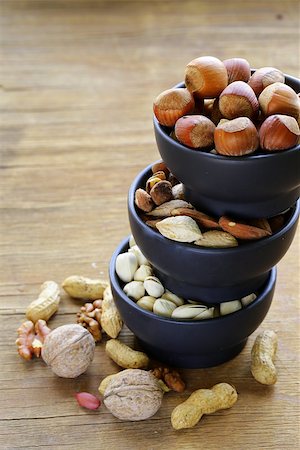 simsearch:400-07310170,k - different kinds of nuts (almonds, walnuts, hazelnuts, peanuts) in a bowl on a wooden table Fotografie stock - Microstock e Abbonamento, Codice: 400-07716999