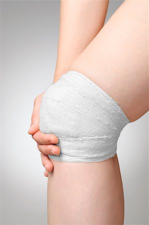 simsearch:400-07831838,k - Injured painful knee with white gauze bandage Foto de stock - Royalty-Free Super Valor e Assinatura, Número: 400-07718060