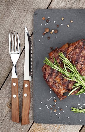 Beef steaks with rosemary and spices on wooden table Foto de stock - Super Valor sin royalties y Suscripción, Código: 400-07719028