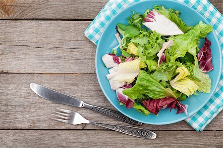 simsearch:400-06485512,k - Plate with fresh salad, knife and fork. Diet food on wooden table with copy space Stock Photo - Budget Royalty-Free & Subscription, Code: 400-07719043