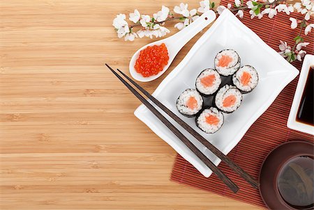 simsearch:400-07719212,k - Red caviar, sushi set, sakura branch and chopsticks over bamboo table with copy space Fotografie stock - Microstock e Abbonamento, Codice: 400-07719214