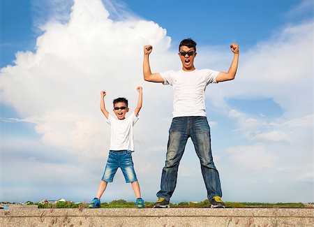 father and son standing  and raising hands Stock Photo - Budget Royalty-Free & Subscription, Code: 400-07719999