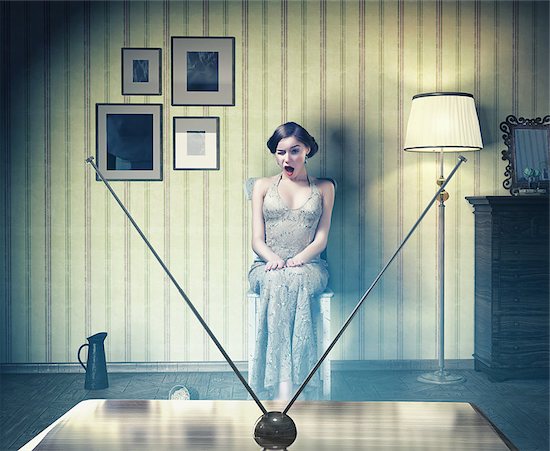Surprised beautiful girl in the vintage interior,watching tv. Creative concept Stock Photo - Royalty-Free, Artist: vicnt, Image code: 400-07712545