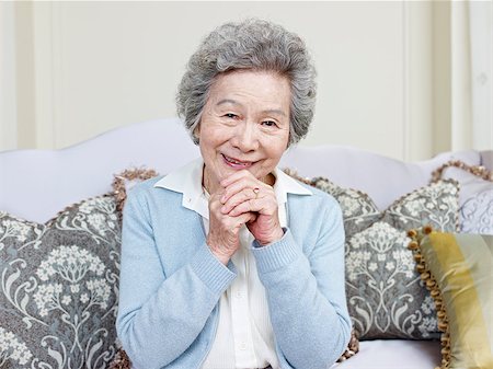 simsearch:400-04563959,k - senior asian woman sitting on couch smiling. Photographie de stock - Aubaine LD & Abonnement, Code: 400-07712878