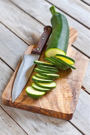 simsearch:400-07713408,k - Sliced zucchini on wooden plank with knife. Selective focus. Stock Photo - Budget Royalty-Free & Subscription, Code: 400-07713395