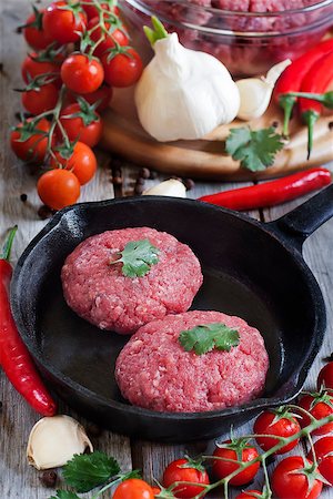 simsearch:695-05773492,k - Raw meatballs on iron pan with chili pepper, cherry tomato and garlic. Selective focus. Fotografie stock - Microstock e Abbonamento, Codice: 400-07713408