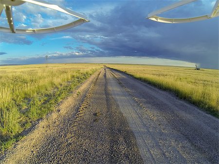 drone uav - aerial view from a landing drone on a dirt road in Pawnee National Grassland with windmill and oil rig Stock Photo - Budget Royalty-Free & Subscription, Code: 400-07713821