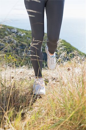 simsearch:400-07725266,k - Fit woman jogging on mountain trail on a sunny day Photographie de stock - Aubaine LD & Abonnement, Code: 400-07724205