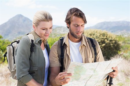 people on trail with map - Attractive hiking couple reading the map on mountain trail on a sunny day Stock Photo - Budget Royalty-Free & Subscription, Code: 400-07724243