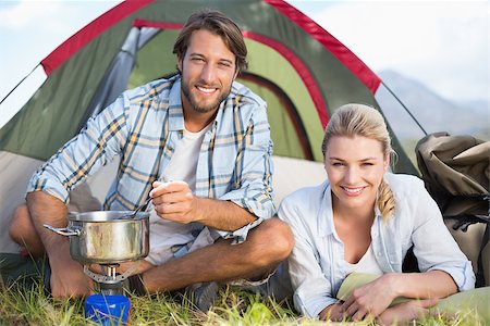 Attractive happy couple cooking on camping stove on a sunny day Stock Photo - Budget Royalty-Free & Subscription, Code: 400-07724277