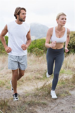 simsearch:400-08017390,k - Attractive couple jogging on mountain trail on a sunny day Photographie de stock - Aubaine LD & Abonnement, Code: 400-07724293