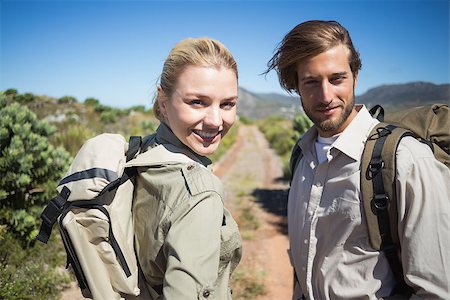 Hiking couple walking on mountain terrain smiling at camera on a sunny day Stock Photo - Budget Royalty-Free & Subscription, Code: 400-07724435