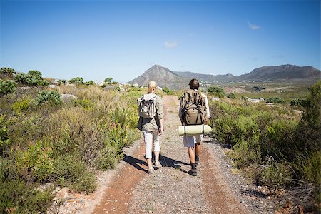Hiking couple walking on mountain terrain on a sunny day Stock Photo - Budget Royalty-Free & Subscription, Code: 400-07724437