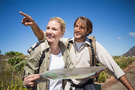 Hiking couple walking on mountain terrain looking at map on a sunny day Stock Photo - Budget Royalty-Free & Subscription, Code: 400-07724439