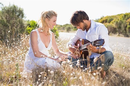 serenade - Handsome man serenading his girlfriend with guitar on a sunny day Stock Photo - Budget Royalty-Free & Subscription, Code: 400-07724477