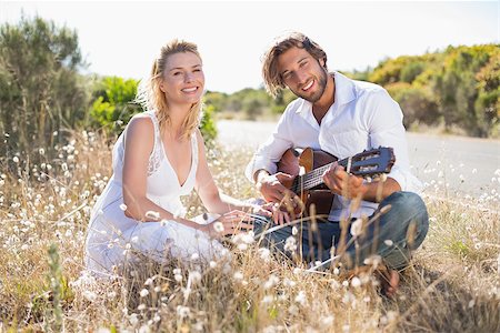 serenade - Handsome man serenading his girlfriend with guitar on a sunny day Stock Photo - Budget Royalty-Free & Subscription, Code: 400-07724478