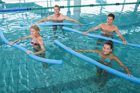 simsearch:400-07724709,k - Happy fitness class doing aqua aerobics with foam rollers in swimming pool at the leisure centre Stock Photo - Budget Royalty-Free & Subscription, Code: 400-07724793