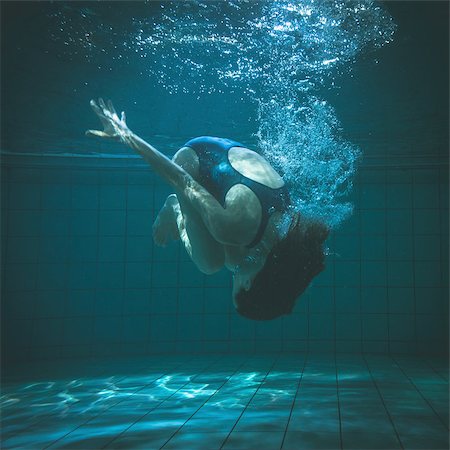 Athletic swimmer doing a somersault underwater in the swimming pool at the leisure centre Foto de stock - Royalty-Free Super Valor e Assinatura, Número: 400-07724883