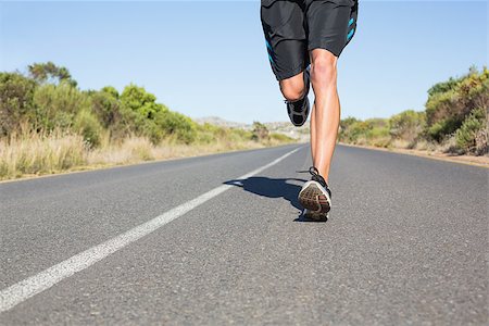 simsearch:400-08017390,k - Fit man jogging on the open road on a sunny day Photographie de stock - Aubaine LD & Abonnement, Code: 400-07724968