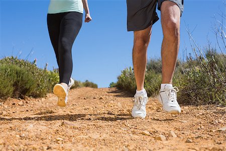 simsearch:400-08017390,k - Fit couple running down mountain trail on a sunny day Photographie de stock - Aubaine LD & Abonnement, Code: 400-07725038