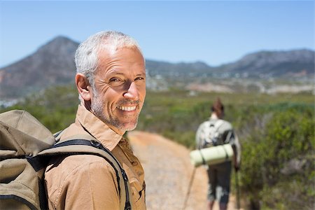 Hiking couple walking on mountain trail man smiling at camera on a sunny day Stock Photo - Budget Royalty-Free & Subscription, Code: 400-07725094