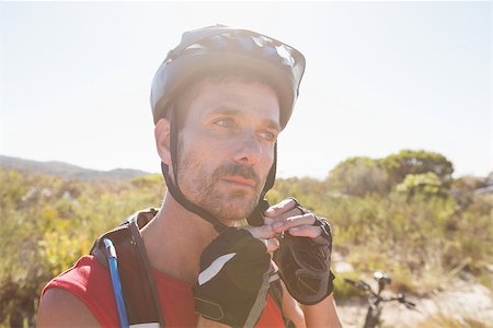 pictures of the cyclist track - Fit cyclist adjusting helmet strap on country terrain on a sunny day Stock Photo - Budget Royalty-Free & Subscription, Code: 400-07725236